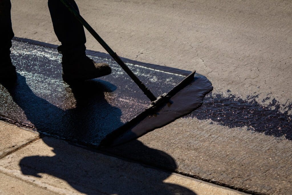 Sealcoat being applied to asphalt