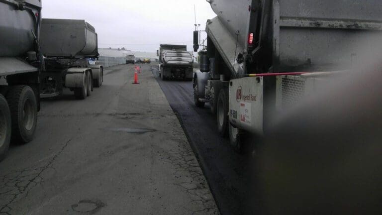 Trucks driving on a newly paved road