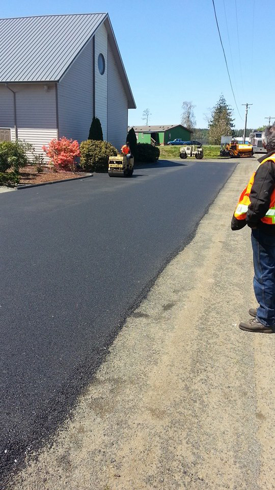 Worker looking at newly paved parking lot of a church