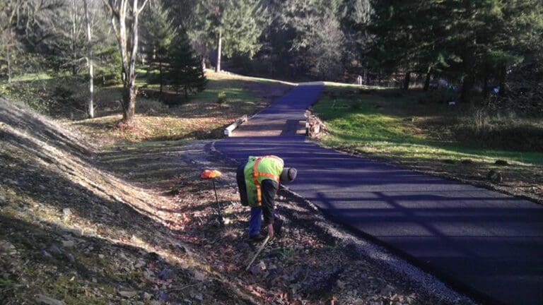 Worker clearing debris from newly paved road