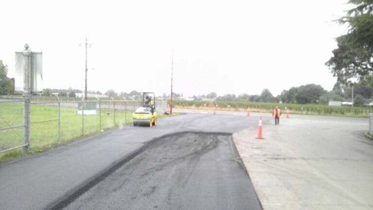 Road roller flattening newly paved road