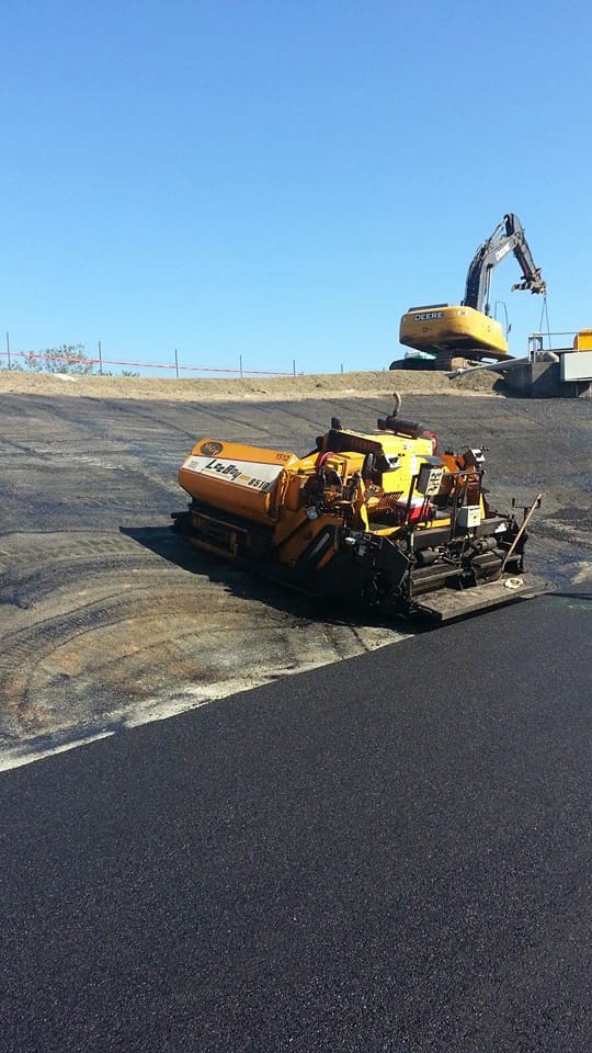 Asphalt paver showing old road and new road