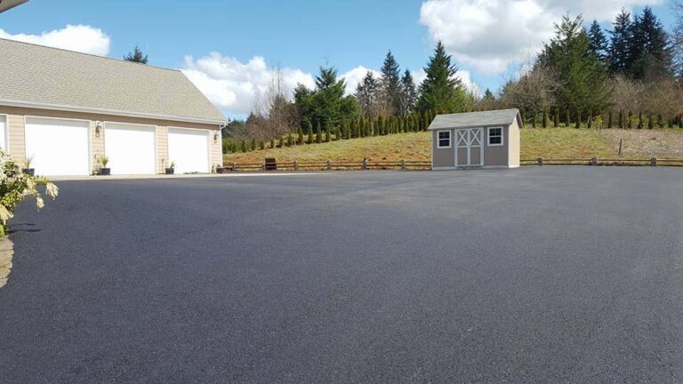 Freshly paved driveway leading to a garage
