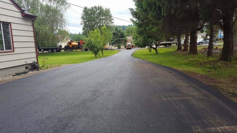 Newly paved driveway with vehicles in the front