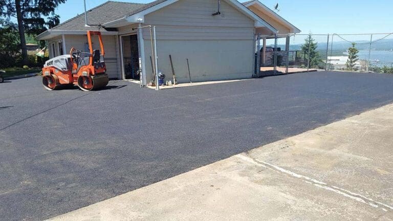 Road roller next to a house on a newly paved driveway