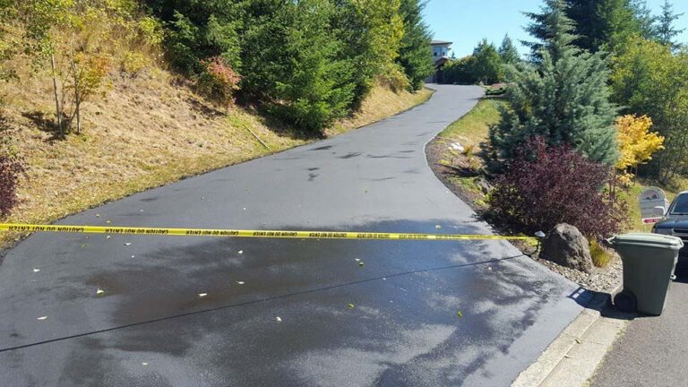 Fresh paved asphalt driveway roped off to dry